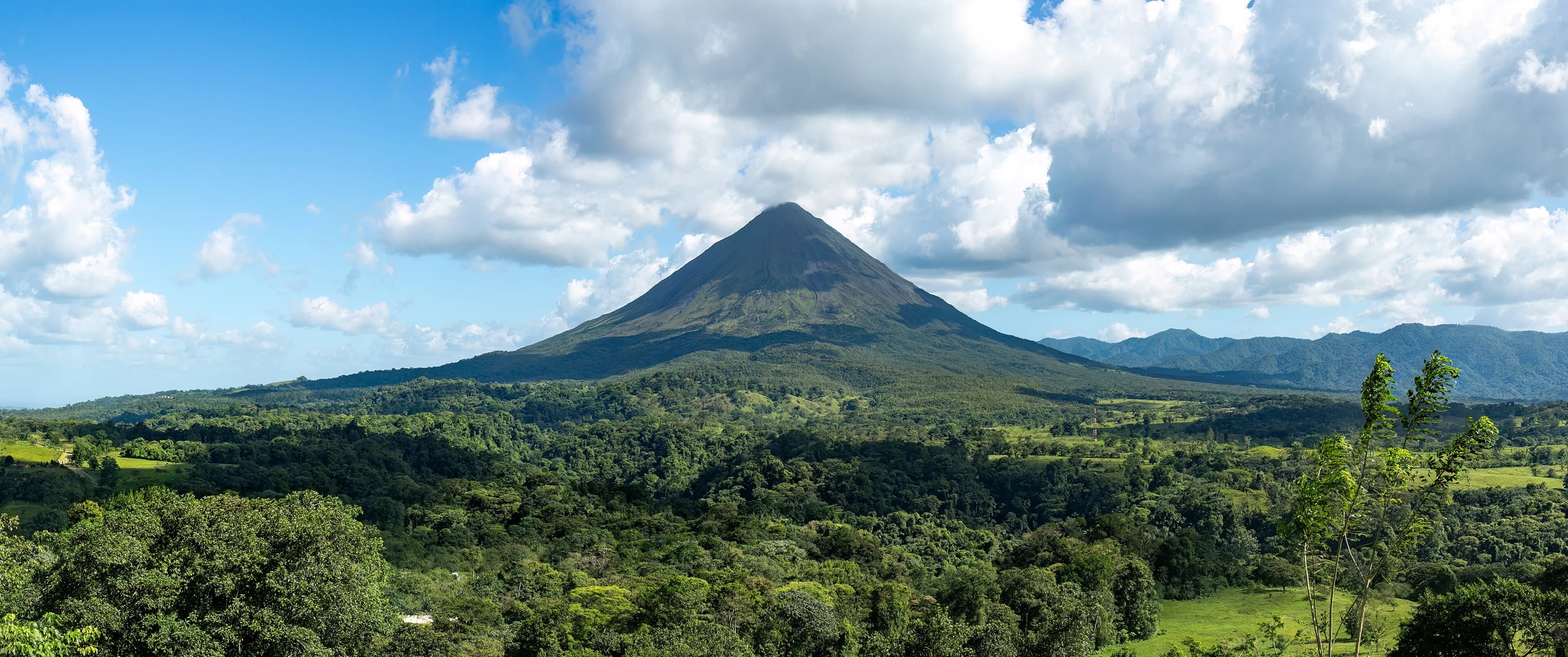 Vulcão Arenal reconhecível acima da floresta, Costa Rica; fotografia de Rhododendrites em 2024.