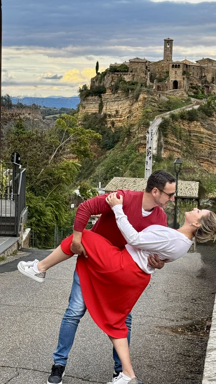 Marcelo e Alexandra em pose romântica com Civita di Bagnoregio ao fundo, Itália