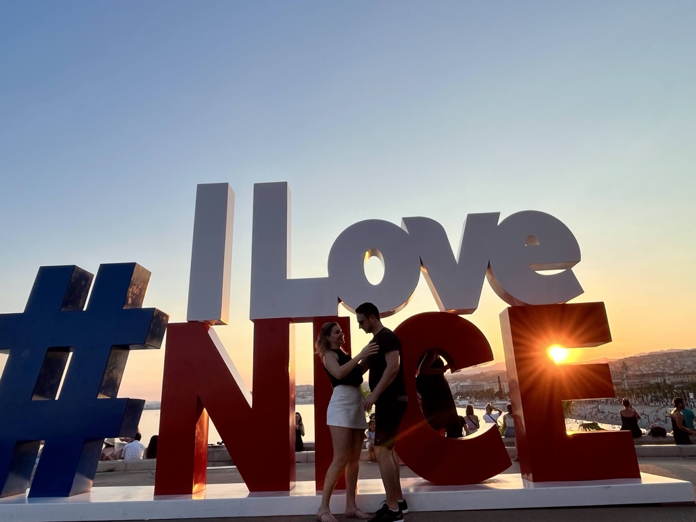 Casal no letreiro I Love Nice ao por do sol