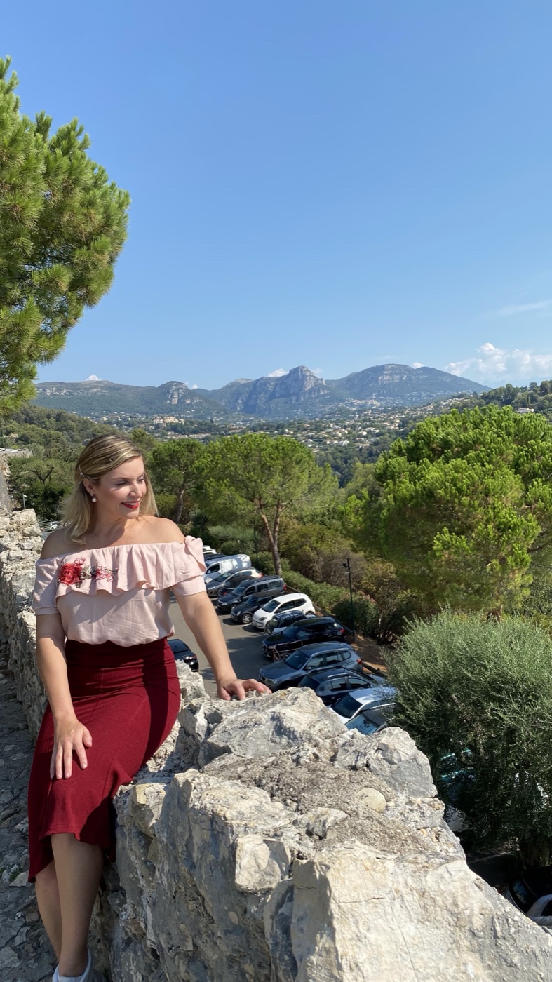 Alexandra nas muralhas de Saint-Paul-de-Vence com vista para as montanhas