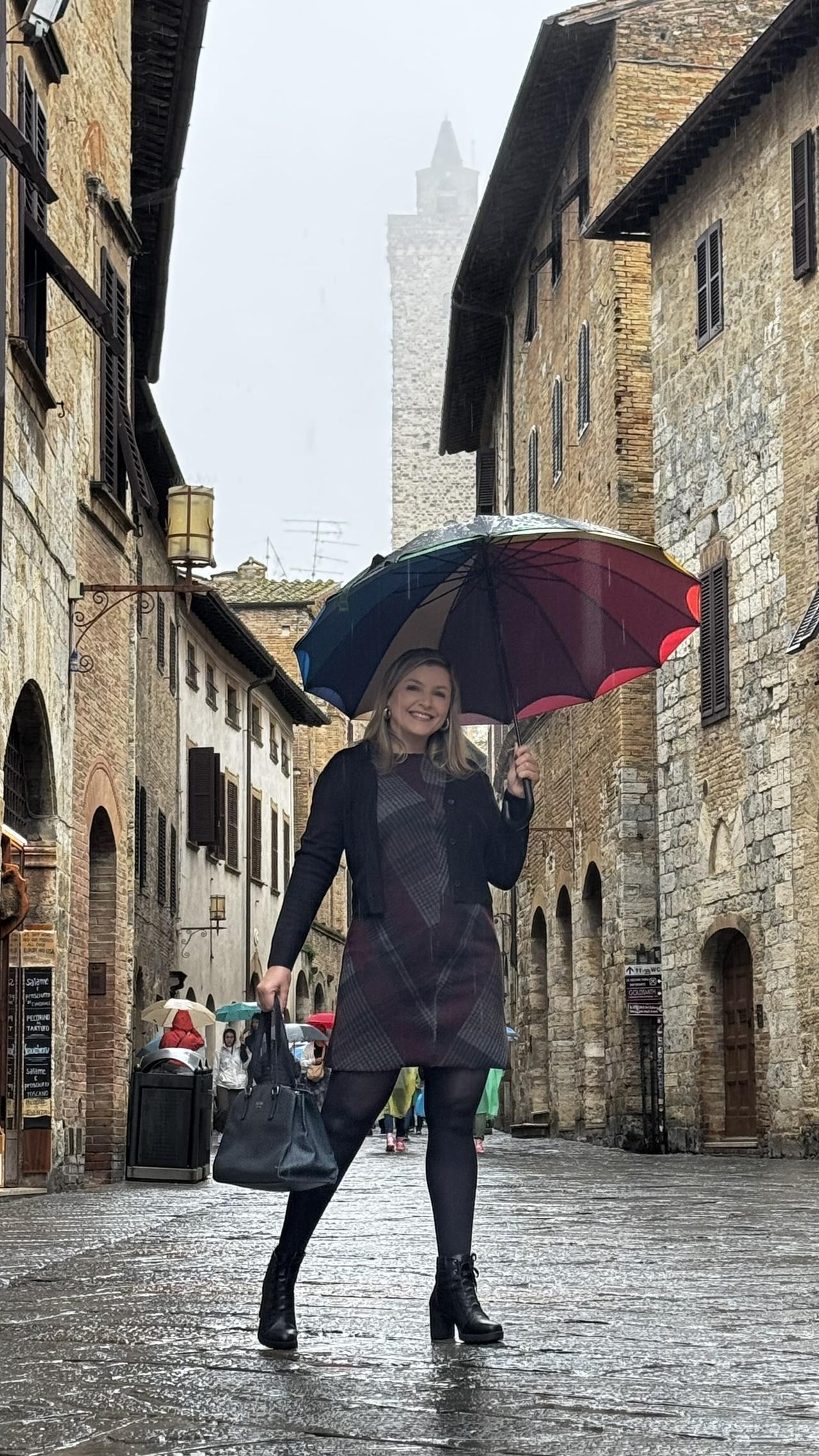 Alexandra com guarda-chuva nas ruas medievais de Monteriggioni, Toscana