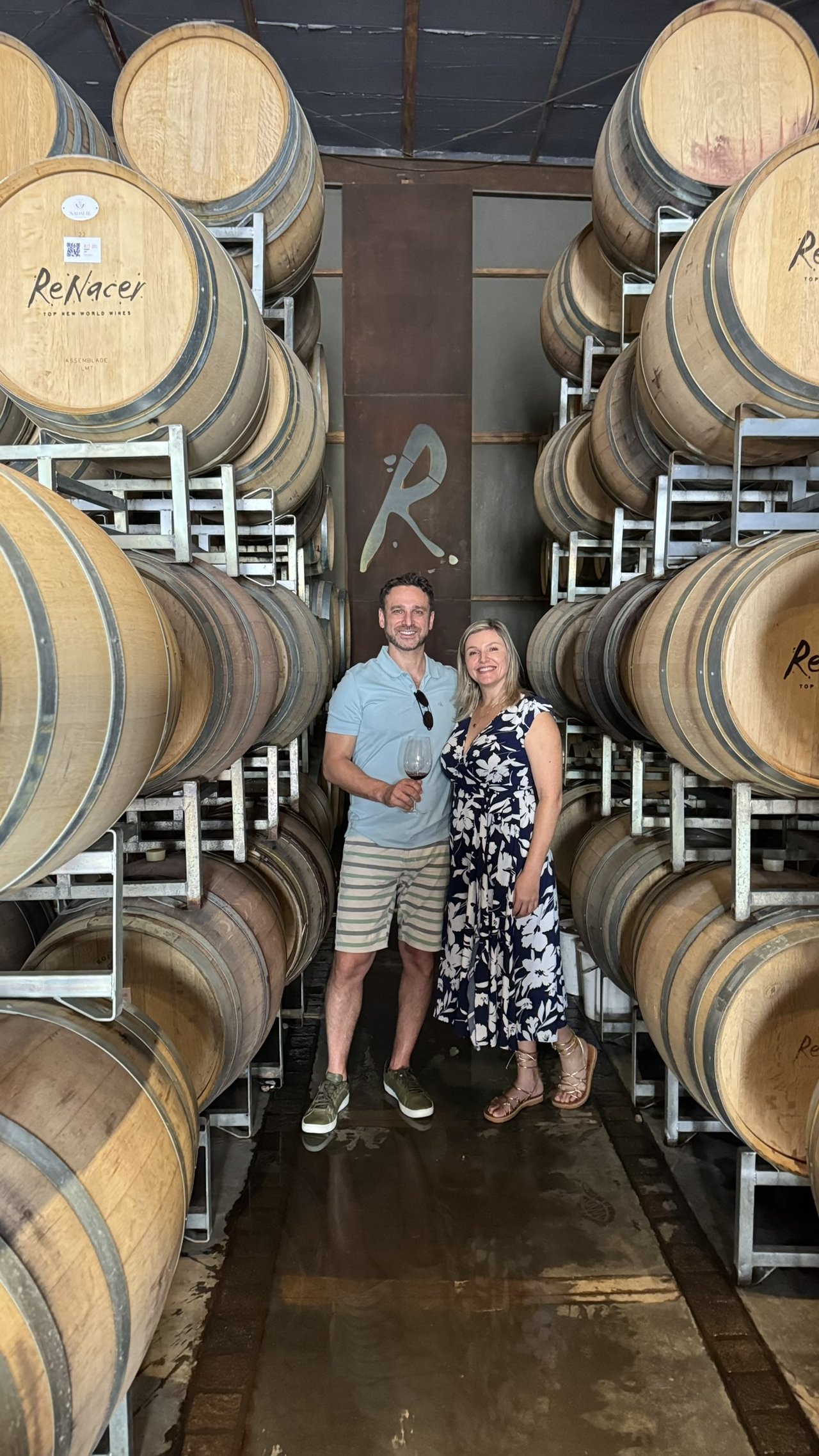 Marcelo e Alexandra na cave da vinicola Renacer entre barris de vinho